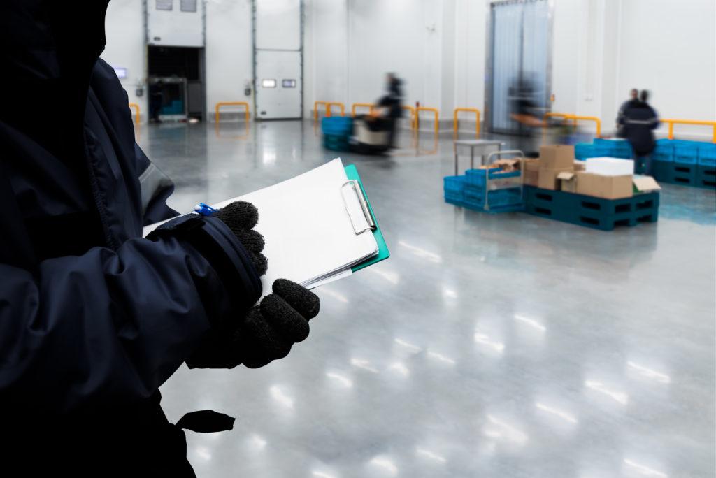 Hand of worker with clipboard checking order